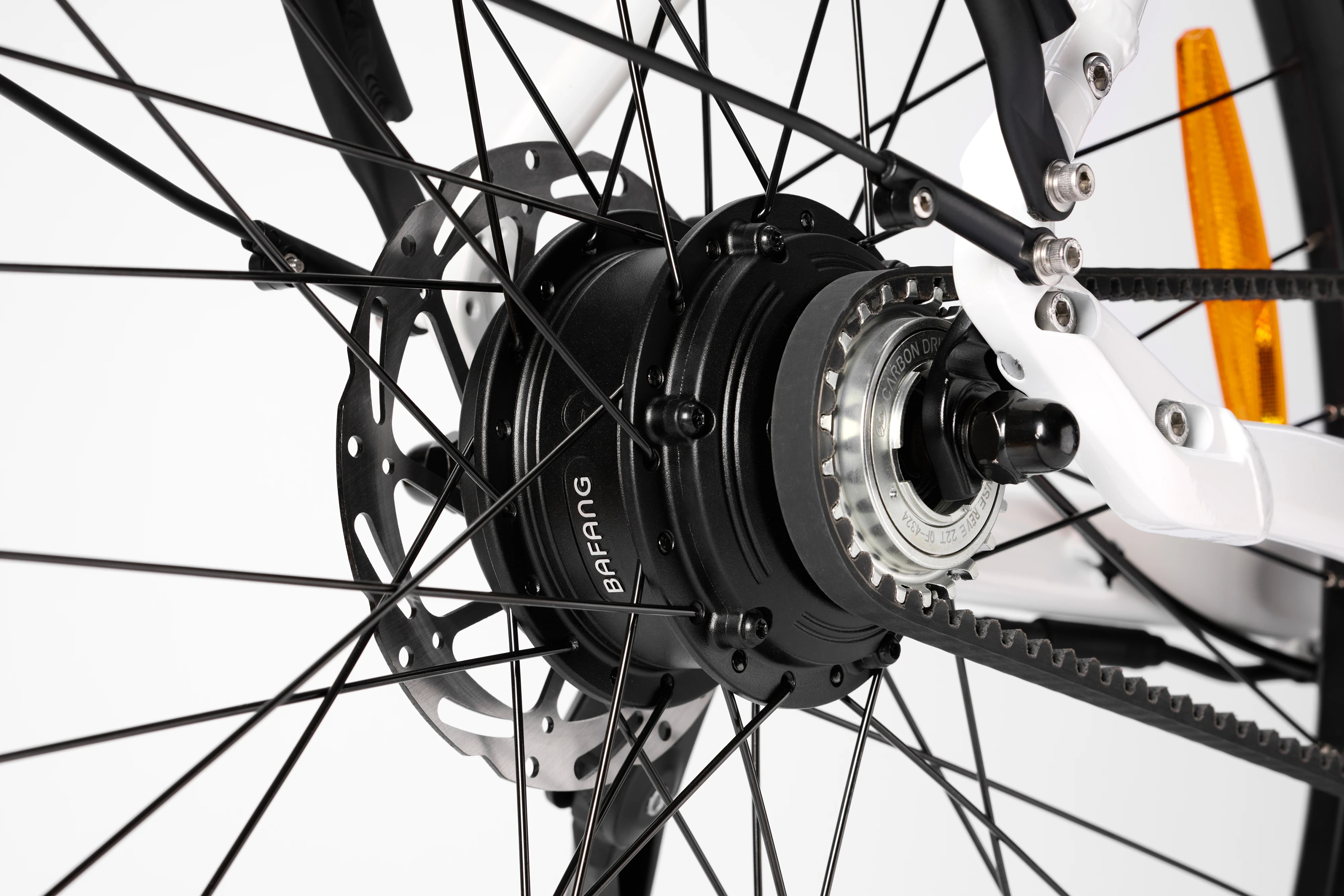 Macro studio shot focusing on the rear wheel hub motor, silver gear cog, spokes, and disc brake assembly of a Stry One electric bicycle.
