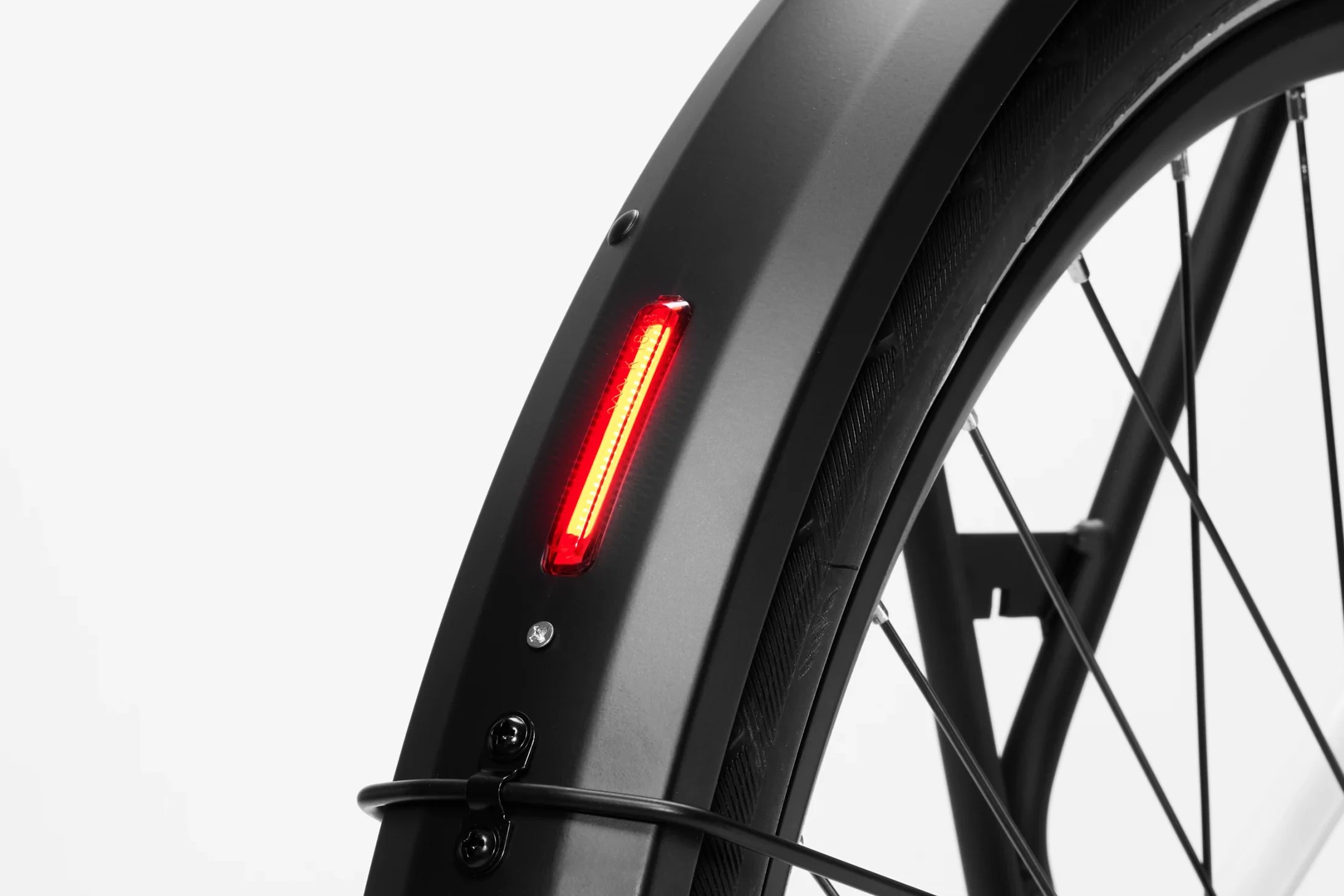 Close-up of the integrated red LED back light on the rear fender of a white Stry One electric bicycle.