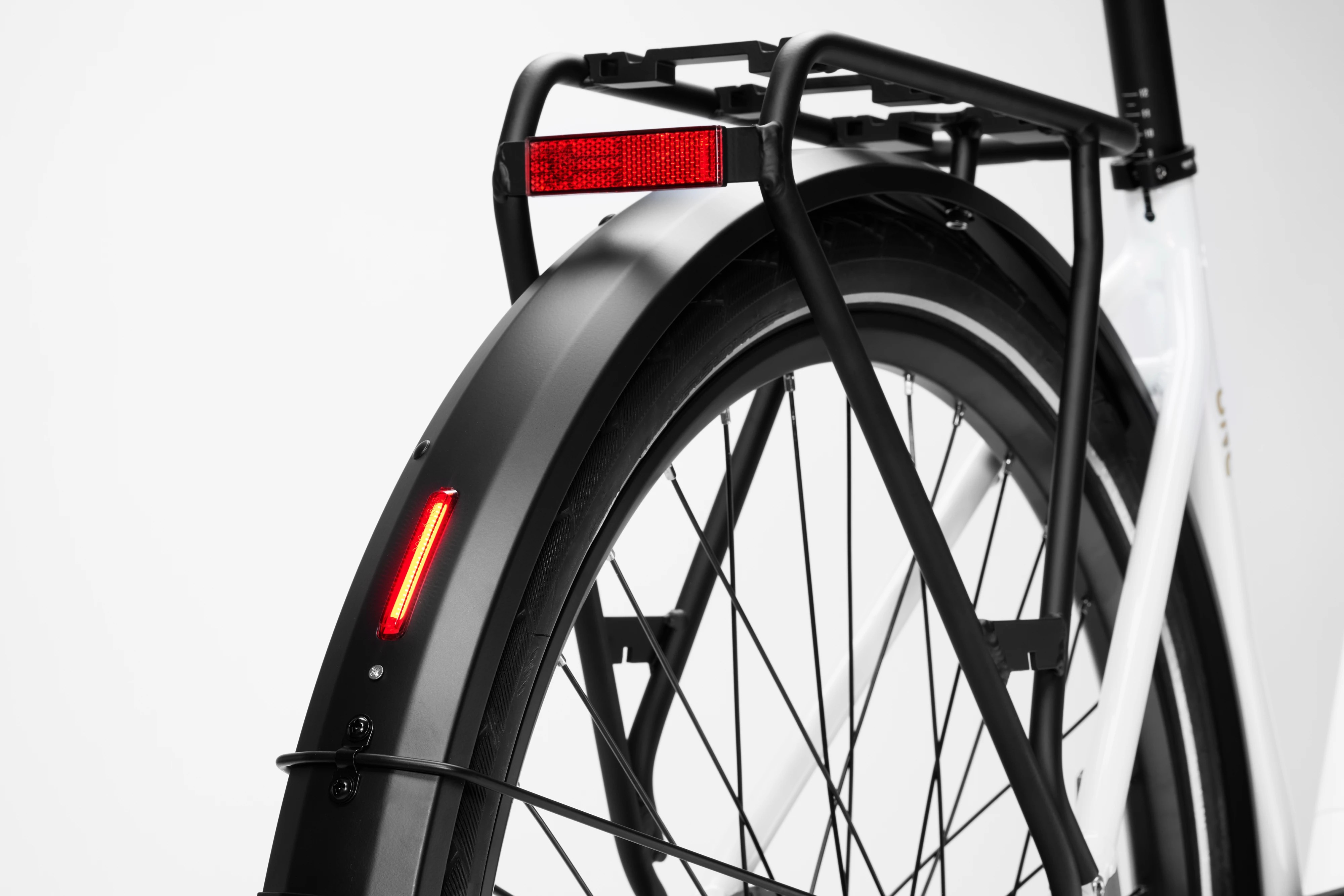 Close-up of the integrated red LED back light on the rear fender of a white Stry One electric bicycle.