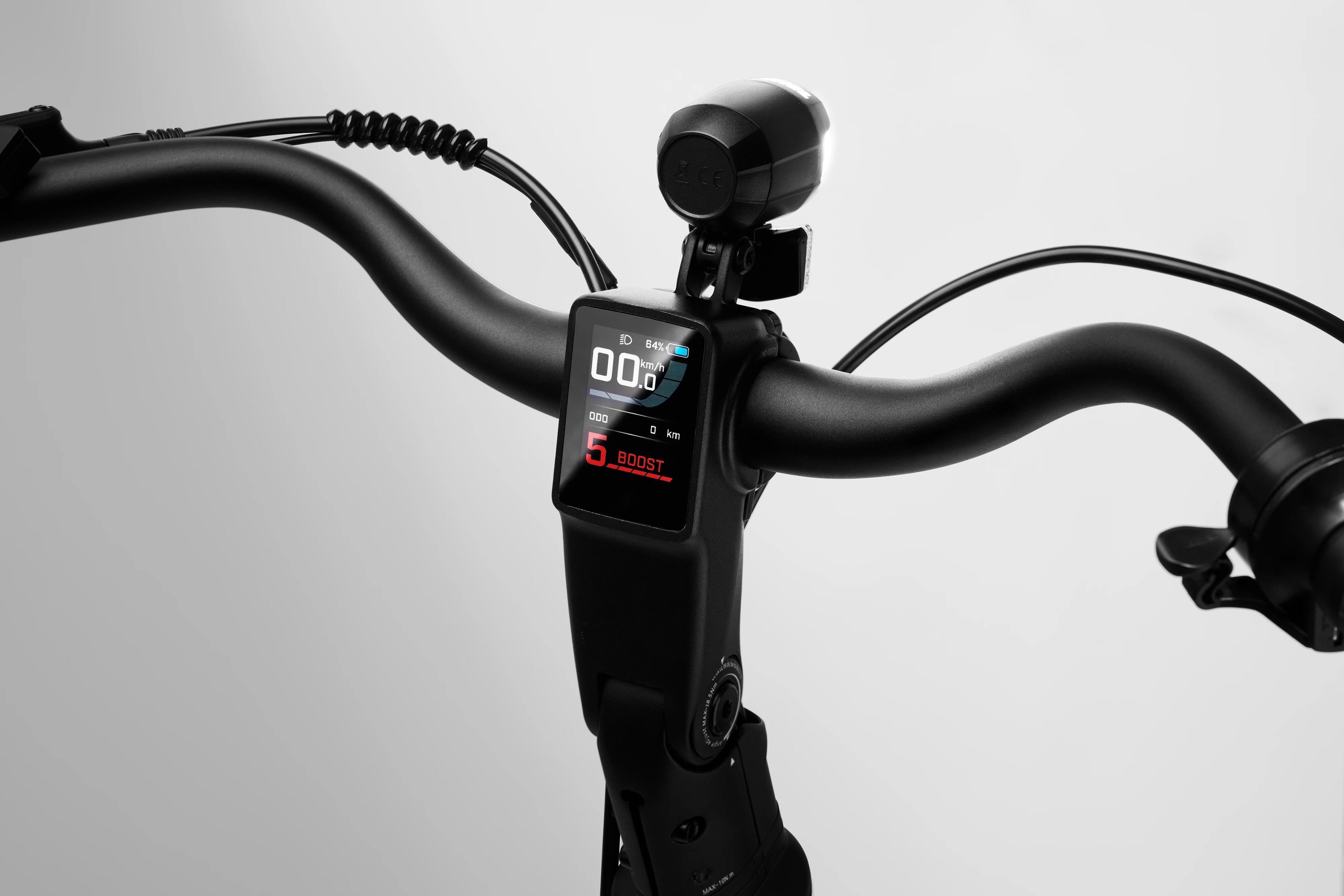 Close-up studio shot of the illuminated digital LCD dashboard display screen mounted on the handlebar stem of a black Stry One electric bicycle.